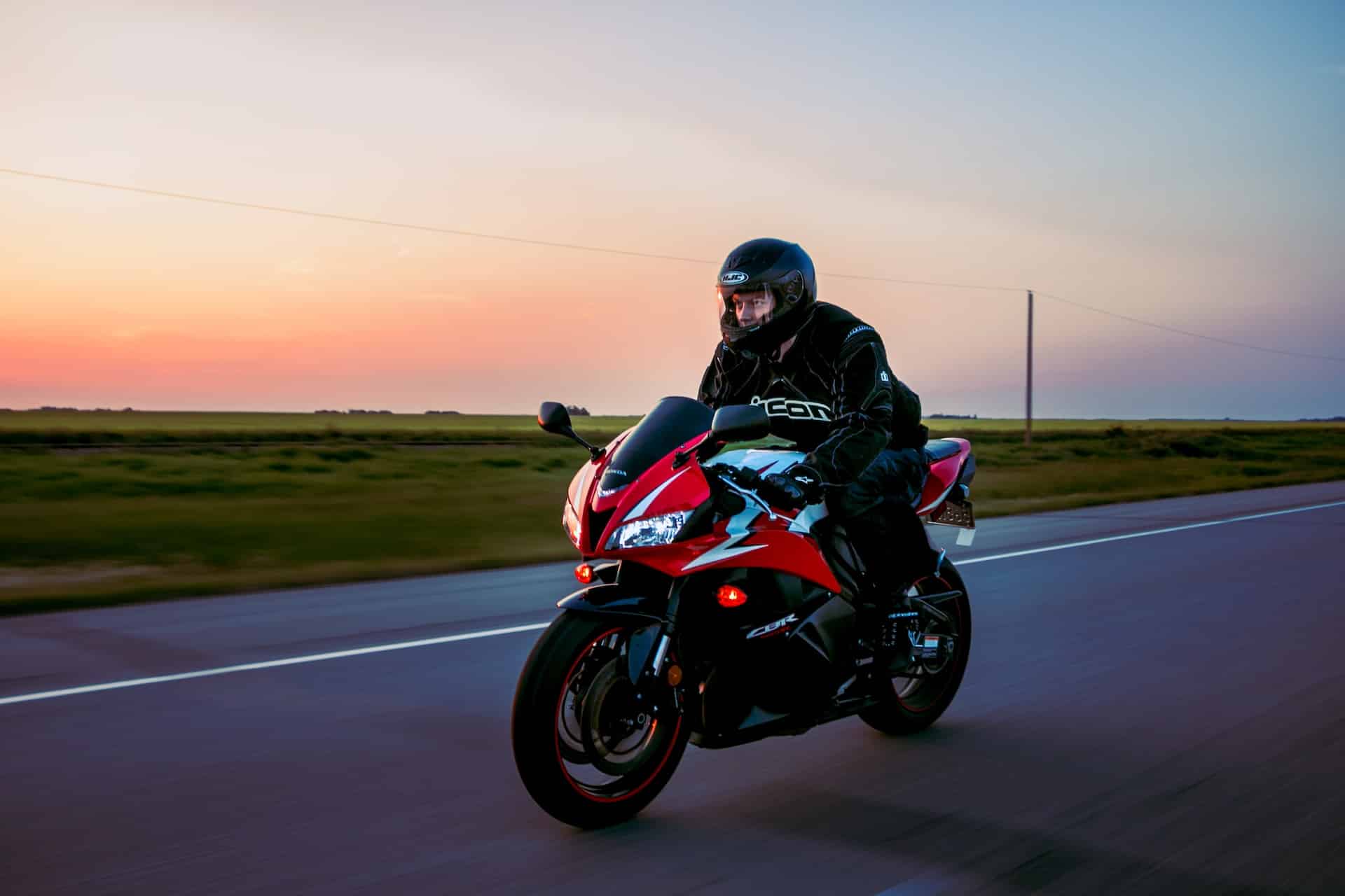 man riding bike on road during sunset